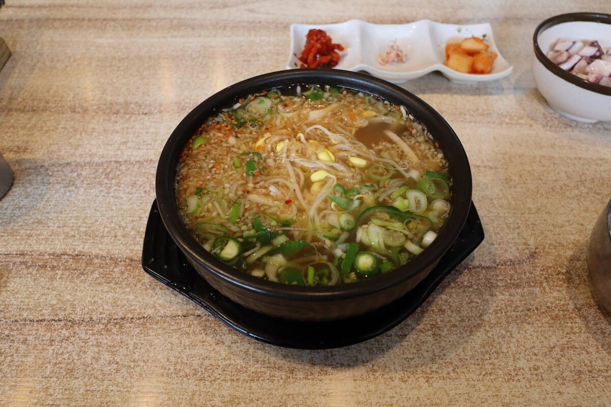 뚝배기에 담긴 콩나물국밥과 곁들임 반찬