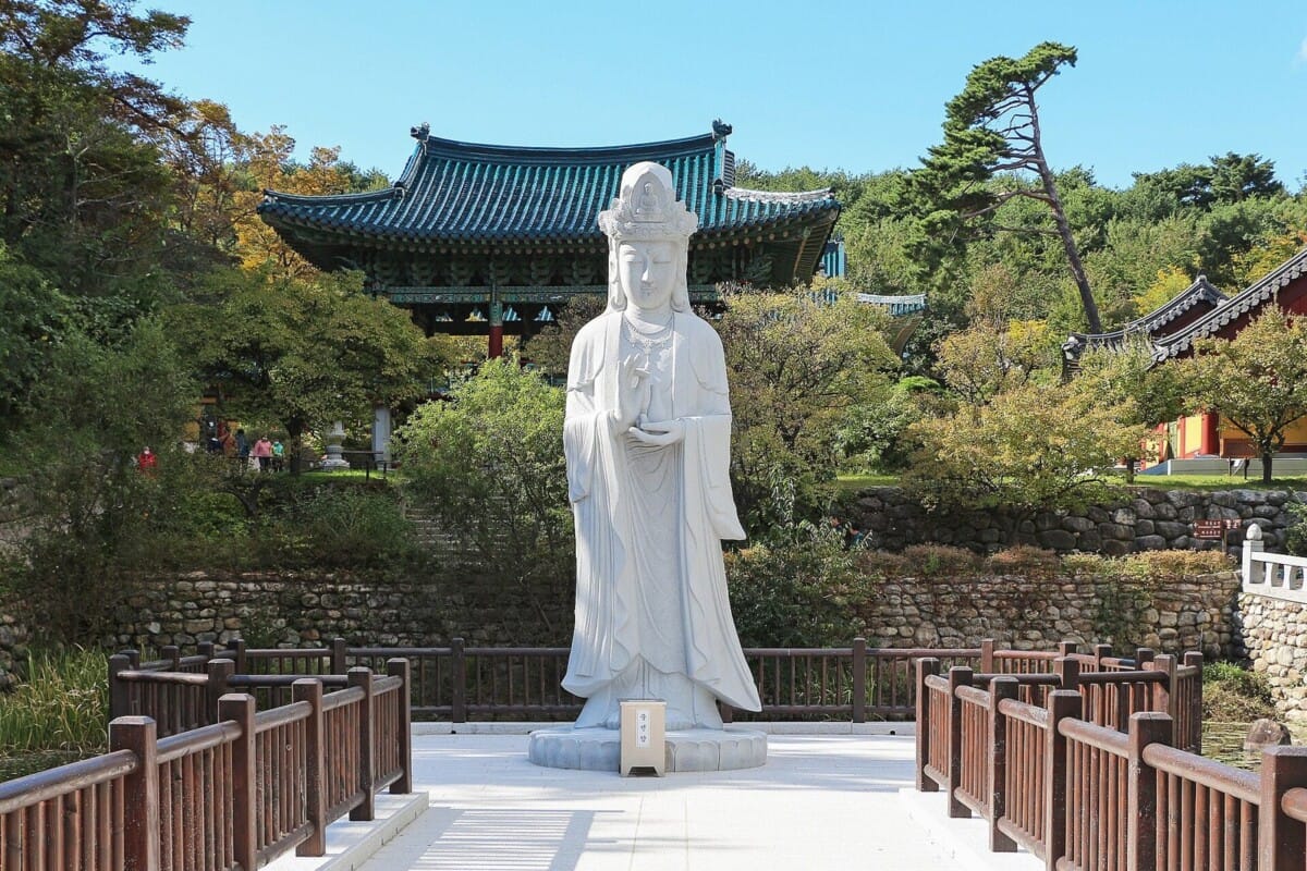 양양 낙산사 경내에 세워진 흰색 보살 석상과 단청 누각