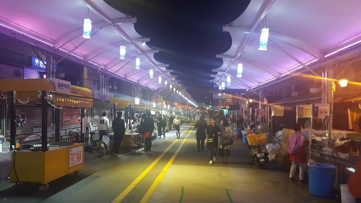밤에 조명이 켜진 한국 전통시장 야시장 거리와 먹거리 노점 행렬