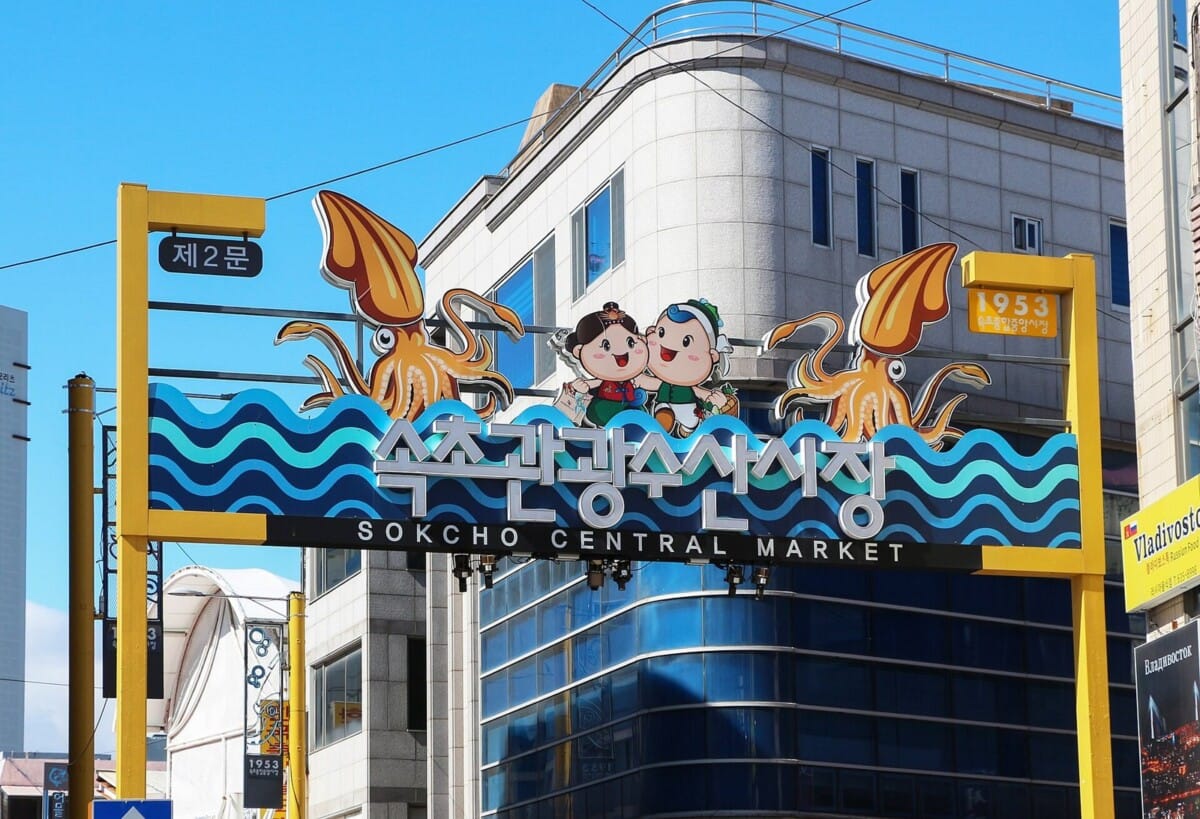 오징어 조형물이 달린 속초관광수산시장 제2문 아치 간판