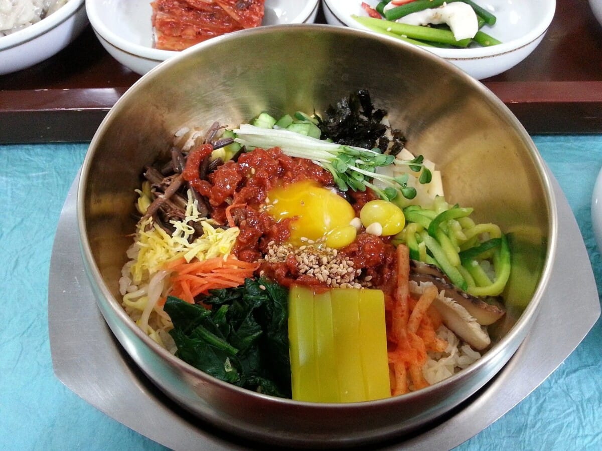 전주비빔밥축제의 주인공인 전주식 비빔밥 한 그릇. 콩나물·고사리·황포묵 등 나물과 고추장, 달걀노른자가 올라간 놋그릇 구성