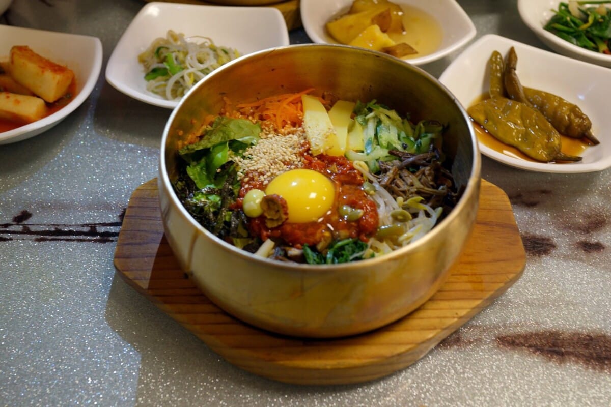 10월 먹거리 축제 대표 메뉴인 전주비빔밥이 유기그릇에 담겨 반찬과 함께 차려진 모습