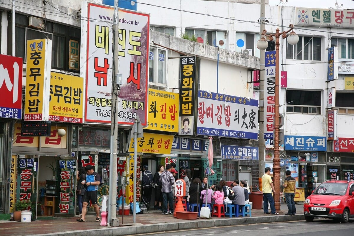 통영 먹거리의 중심인 중앙시장 앞 충무김밥 골목의 간판들과 손님들