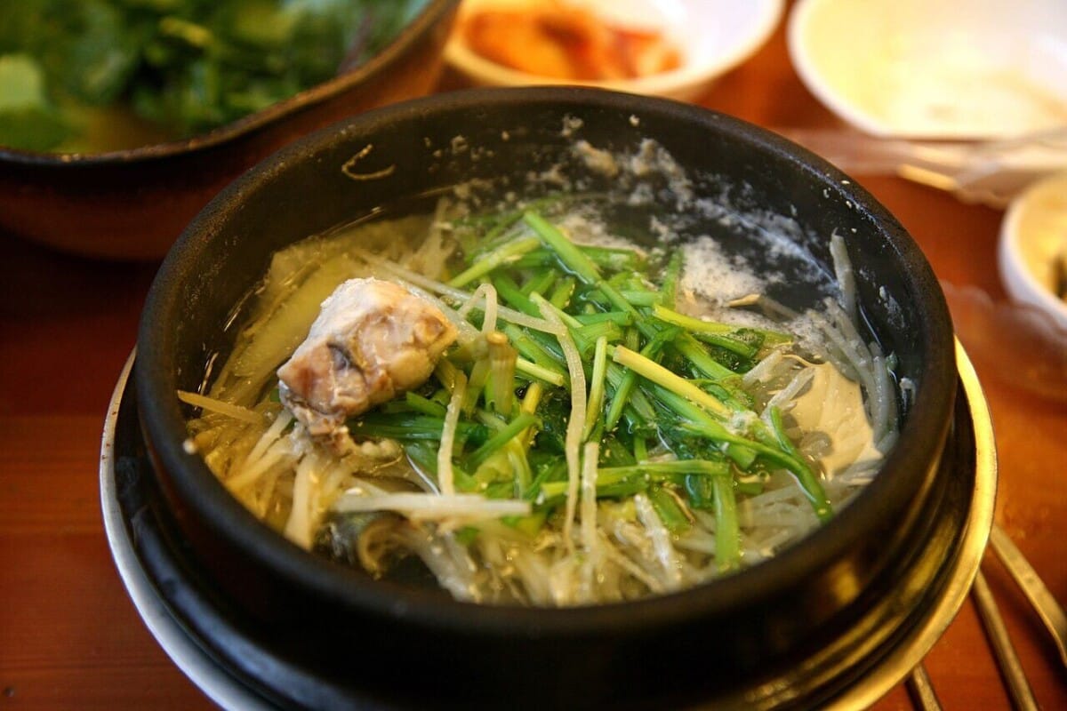 뚝배기에 미나리와 콩나물을 올려 끓여낸 한국식 복국 한 그릇