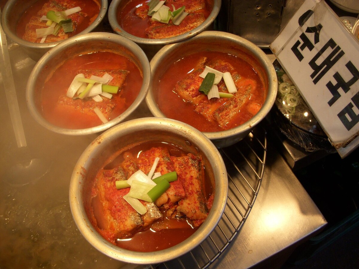 양은 냄비에 담겨 끓고 있는 갈치조림 여러 그릇